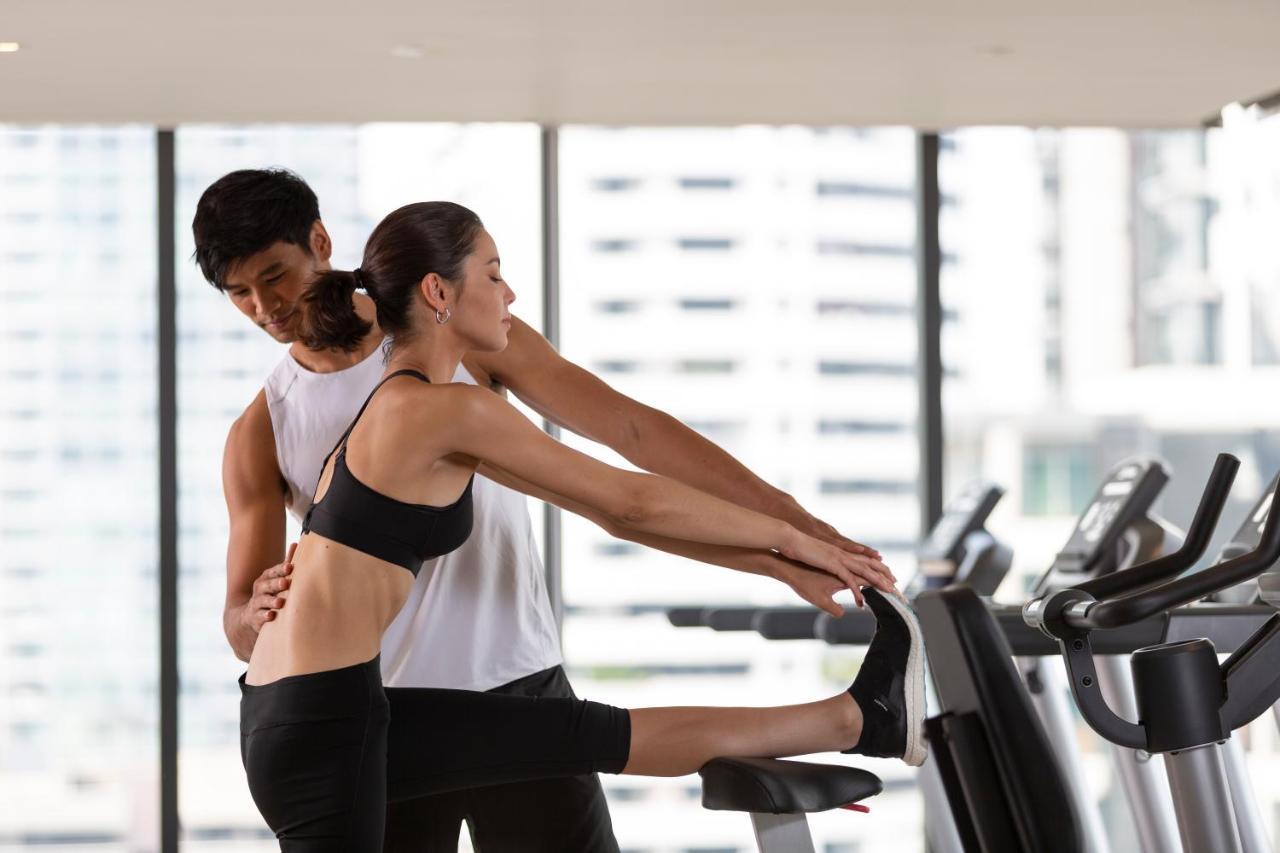 Hotel Ascott Thonglor Bangkok Exterior foto A personal trainer assisting a woman with a stretching exercise